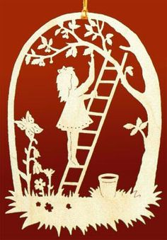 an ornament with a girl on a ladder reaching up to the tree and flowers