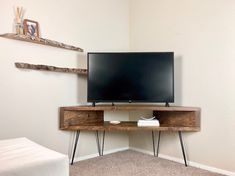 a flat screen tv sitting on top of a wooden stand