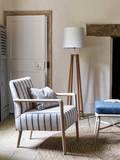 a living room with a chair, lamp and rug