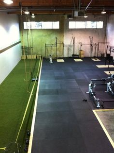 an indoor gym with artificial turf and equipment