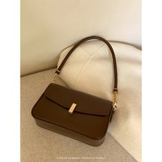 A shoulder bag with a square body and a flap that can hold a smartphone and a small wallet. The golden clasp and small design give it an elegant and stylish impression. It is also possible to remove the shoulder strap. 
 
 
 Color 
 
 Dark brown 
 Black 
 
 
 Size 
 
 
 FREE size 
 
 Height: 14cm 
 Width: 22cm 
 Depth: 6.5cm 
 
 
 
 
 
 Material 
 
 Leather Classic Brown Baguette Bag With Gold-tone Hardware, Brown Rectangular Box Bag With Gold-tone Hardware, Classic Gold Bag With Mobile Phone Pocket, Trendy Brown Office Flap Bag, Classic Gold Bags With Mobile Phone Holder, Classic Gold Bag With Mobile Phone Holder, Luxury Brown Shoulder Bag With Fold Over Clasp, Elegant Brown Crossbody Shoulder Bag, Formal Brown Saddle Shoulder Bag