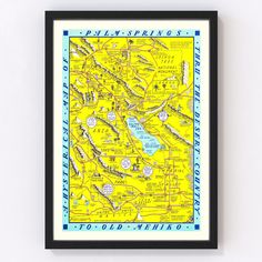 a yellow and blue map hanging on the wall next to a black framed frame with words