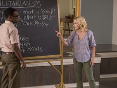 a woman standing next to a man in front of a blackboard with writing on it