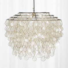 a chandelier hanging from a ceiling in a room with white walls and curtains