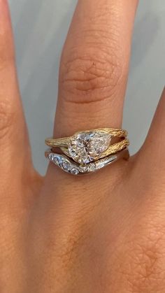 a woman's hand with a gold and white diamond ring on top of it