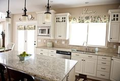 a large kitchen with white cabinets and marble counter tops, along with an island in the middle