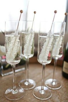 four glasses filled with champagne sitting on top of a table