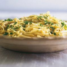 a bowl filled with pasta and parsley on top of a table