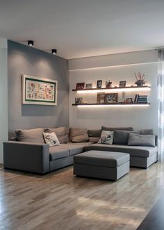 a living room filled with lots of furniture next to a wall mounted tv on top of a wooden floor