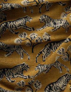 an animal print fabric with black and white tigers on mustard colored background, closeup