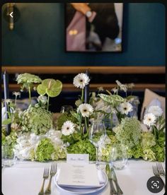 the table is set with flowers and silverware