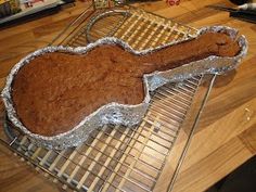 a cookie shaped like an acoustic guitar on a cooling rack