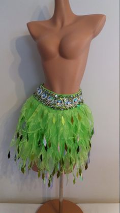 a mannequin wearing a green skirt with sequins and feathers on it