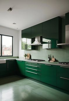 a kitchen with green cabinets and stainless steel appliances in the center, along with a large window