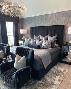 a bed room with a neatly made bed next to a window and a chandelier