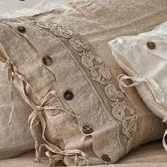 two pillows with buttons on them are sitting on a bed, one is white and the other is beige