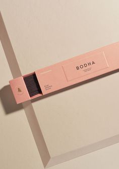 a pink box with the word bodha on it sitting on top of a white surface