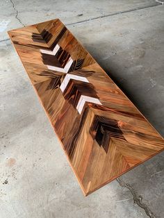 a wooden table with three crosses on it in the middle of concrete flooring area