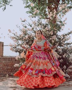 a woman in an orange and pink wedding dress