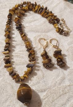 Pretty necklace and earring set made from Tiger Eye Gemstone Pendant and small tiger eye chip beads Pendant is an octagon shape Necklace is of small chip beads Necklace measures 9" long with a extended chain for added sizing. Earrings measures 1.5" long Brown Agate Gemstone Beaded Necklace, Tiger Eye Stone Jewelry, Chip Bead Necklace, Tiger Eye Necklace Handmade, Ocean Springs Ms, Tiger Eye Necklace, Ocean Springs, Beads Pendant, Pretty Necklace