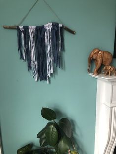 an elephant figurine sitting on top of a shelf next to a potted plant