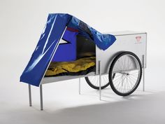 a bike with a tent attached to it's back and wheels on the side