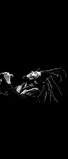 a black and white photo of a man with dreadlocks