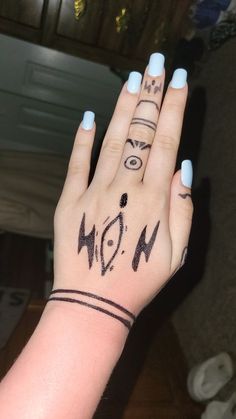 a woman's hand with tattoos on it and the word now written in black ink