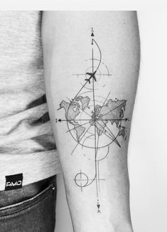 a black and white photo of a man's arm with a compass tattoo on it