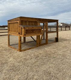 a wooden structure in the middle of a field