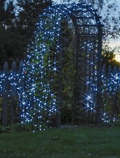 a large metal structure with blue lights on it's sides and trees in the background