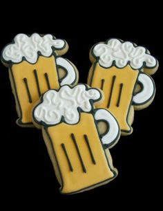 three decorated cookies with beer mugs on them