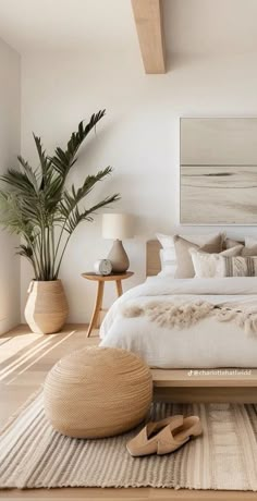 a bedroom with white walls and wooden flooring is furnished with natural materials such as rugs, pillows, blankets and lamps