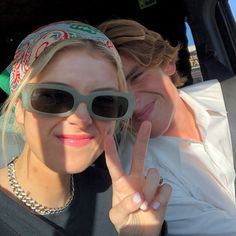 two women in sunglasses making the peace sign