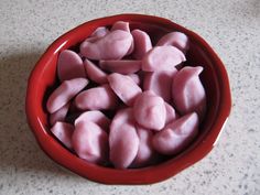 a red bowl filled with pink marshmallows on top of a counter