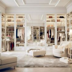 a walk in closet filled with lots of white furniture