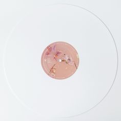 a white record with a pink disc in the middle