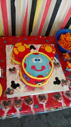 a mickey mouse birthday cake on a table with candy and candies in plastic bags