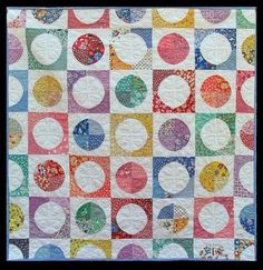 a multicolored quilt with circles on it