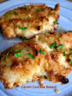 two pieces of fried chicken on a blue plate with parsley green garnish