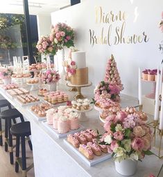 a table with pink flowers and cupcakes on it