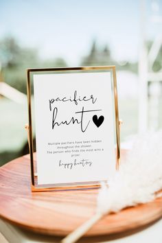 a wooden table topped with a sign and feathers