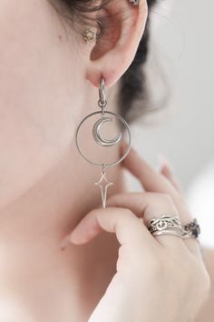 A daring silver moon earring, paired elegantly with a sizeable pointed star.     ★ Hand-crafted to order. ★ Comes as a symmetrical pair. ★ Waterproof & tarnish proof ★ 4 Earring Types Available: Stainless Steel Studs, Stainless Steel Hoops, Stainless Steel Clip-Ons, and 925 Sterling Silver Hooks. ★ Exclusively made 100% unique. ★ Packaged on black tags and wrapped. ★ Charm materials: stainless steel Moon Earring, Y2k Alt, Alt Aesthetic, Earrings Moon, Star Silver, Star Moon, Silver Moon, Moon Earrings, Moon Star