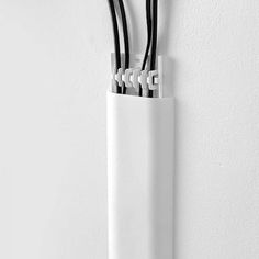 three black and white wires are in an electrical device holder on the wall, which is attached to a hook