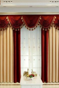 a living room with red curtains and gold trimmings on the window sill