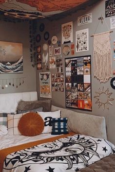 a bed room with a neatly made bed and many pictures on the wall above it