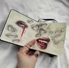 someone is holding an open book with pictures of their faces on it and blood dripping from the mouth