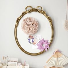 there is a mirror on the wall with some decorations in front of it and a fan