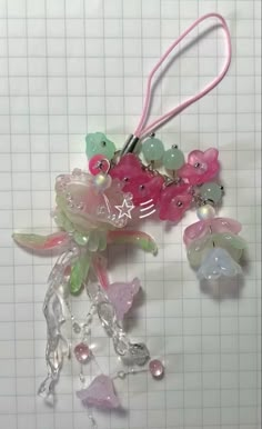 some pink and green beads are hanging from a string