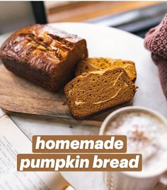 homemade pumpkin bread on a cutting board next to a cup of coffee and an open book